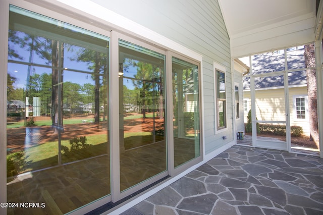 unfurnished sunroom featuring lofted ceiling