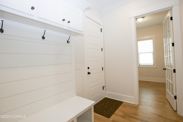 mudroom with light hardwood / wood-style flooring and ornamental molding