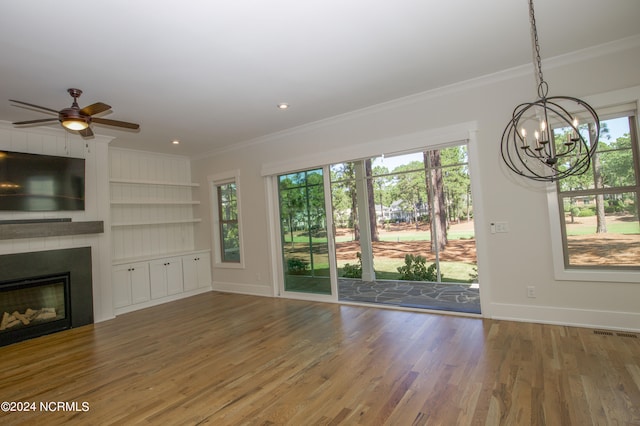 unfurnished living room featuring crown molding, ceiling fan with notable chandelier, and hardwood / wood-style floors