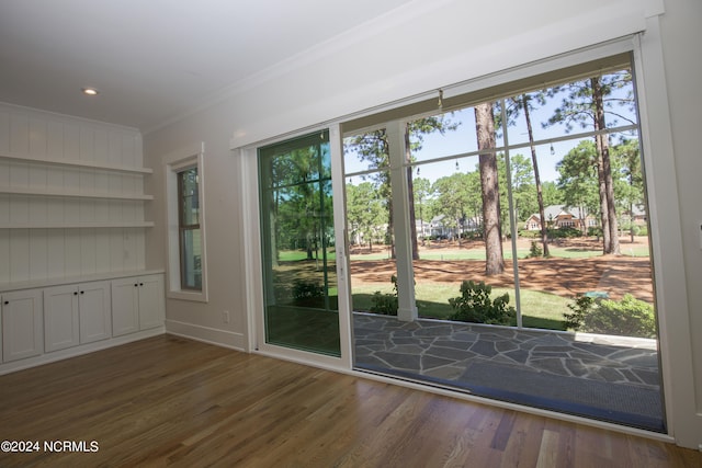 doorway to outside featuring crown molding, plenty of natural light, and dark hardwood / wood-style floors