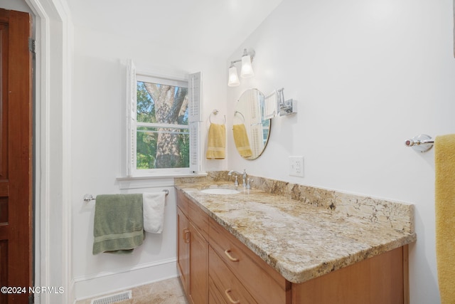 bathroom with vanity and lofted ceiling