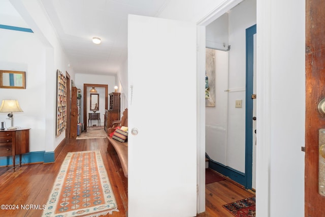 corridor with hardwood / wood-style flooring