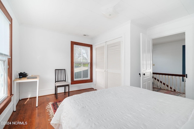 bedroom with crown molding, a closet, and dark hardwood / wood-style flooring