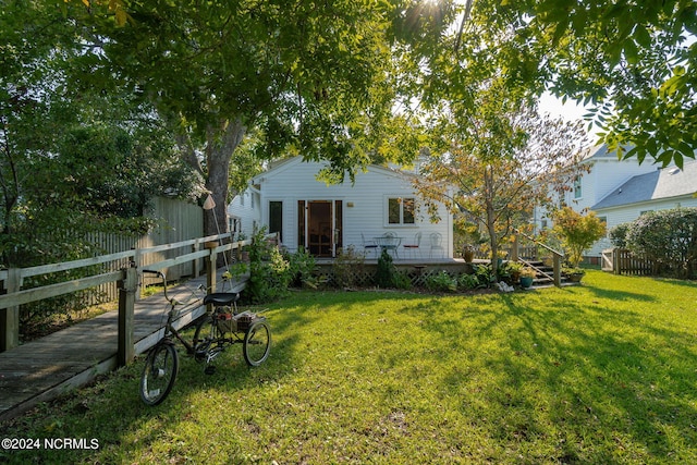 exterior space featuring a wooden deck and a lawn