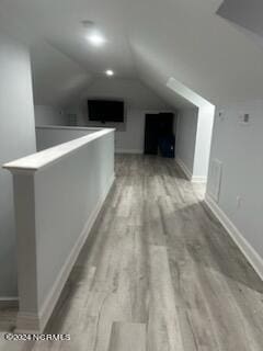 bonus room featuring vaulted ceiling and light hardwood / wood-style floors