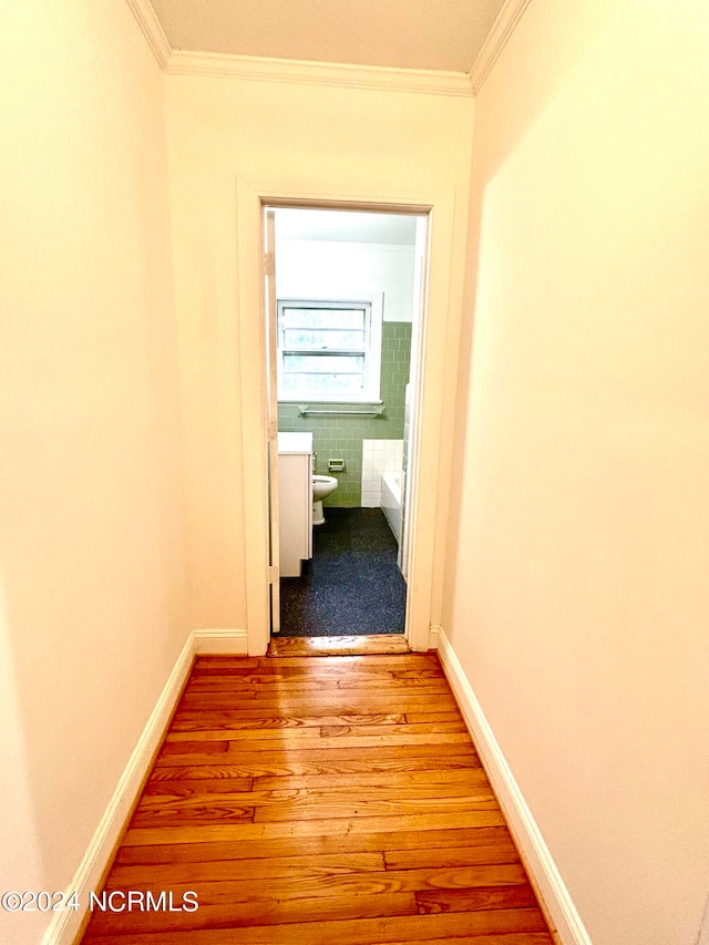 corridor featuring hardwood / wood-style flooring and crown molding