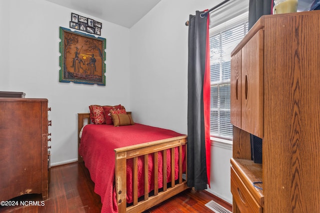 bedroom featuring visible vents, baseboards, and wood finished floors