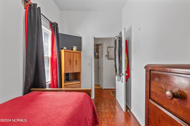 bedroom with dark hardwood / wood-style floors and multiple windows