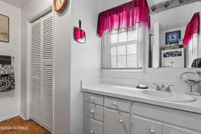 bathroom featuring vanity, a closet, and tile patterned floors