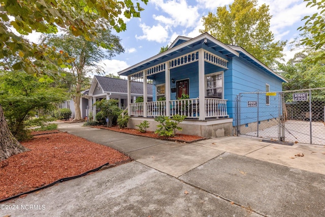 view of front of house featuring a porch, crawl space, and a gate