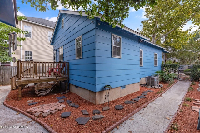 view of property exterior with central AC unit and a wooden deck