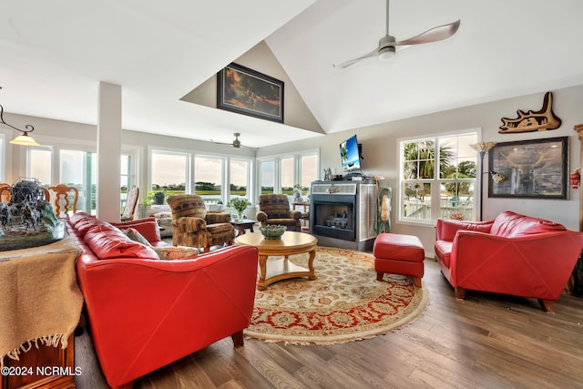 living room with ceiling fan, wood-type flooring, and high vaulted ceiling