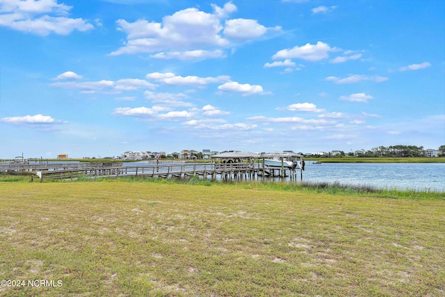 dock area featuring a lawn and a water view