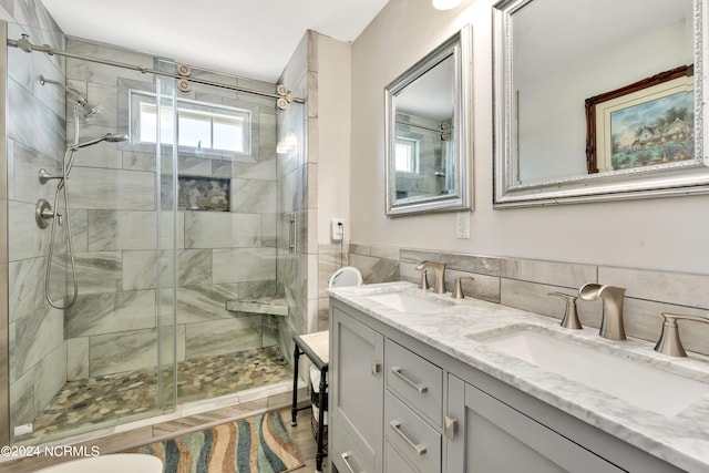 bathroom with walk in shower, vanity, and tile walls