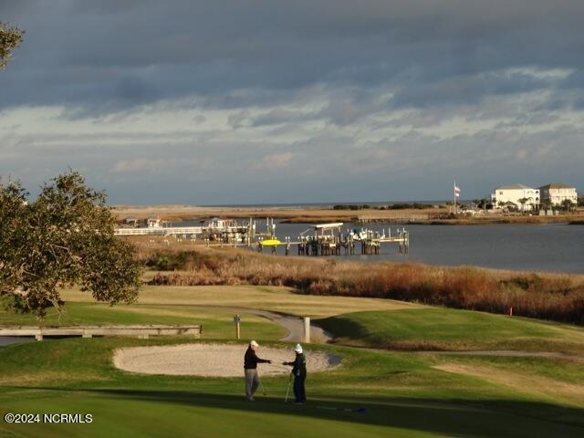 surrounding community with a water view and a yard