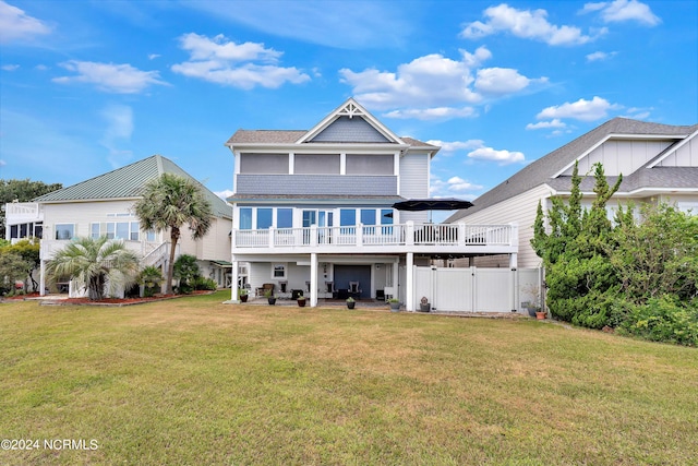 rear view of property with an outdoor living space, a patio area, and a lawn