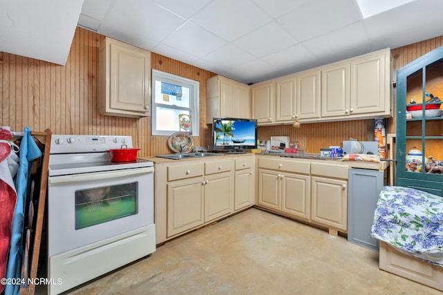 kitchen with wood walls, white electric range, and sink