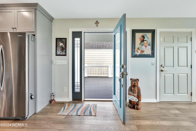 foyer with french doors and light hardwood / wood-style floors