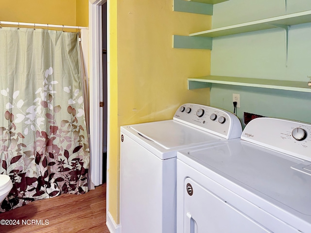 laundry area with light hardwood / wood-style flooring and washing machine and dryer