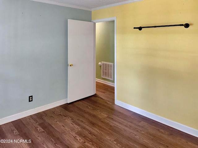 unfurnished bedroom with dark wood-type flooring and ornamental molding