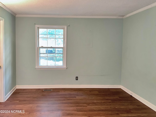 empty room with crown molding, dark wood-type flooring, a textured ceiling, and plenty of natural light