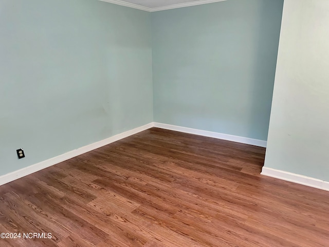 spare room featuring crown molding and hardwood / wood-style floors