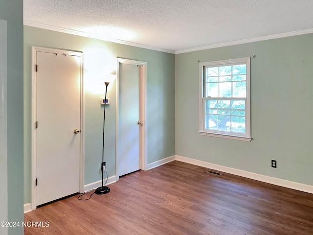 unfurnished room featuring ornamental molding, a textured ceiling, and hardwood / wood-style floors