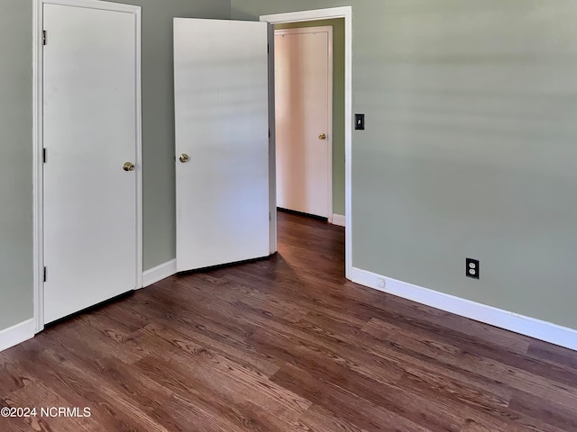 unfurnished bedroom with dark hardwood / wood-style flooring