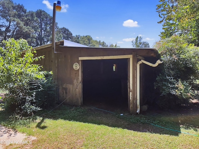 exterior space featuring wood walls and a lawn