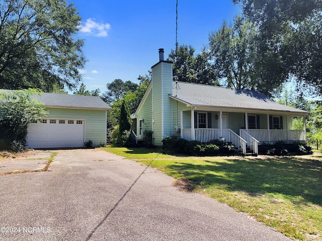 view of front of home featuring a garage, covered porch, and a front lawn