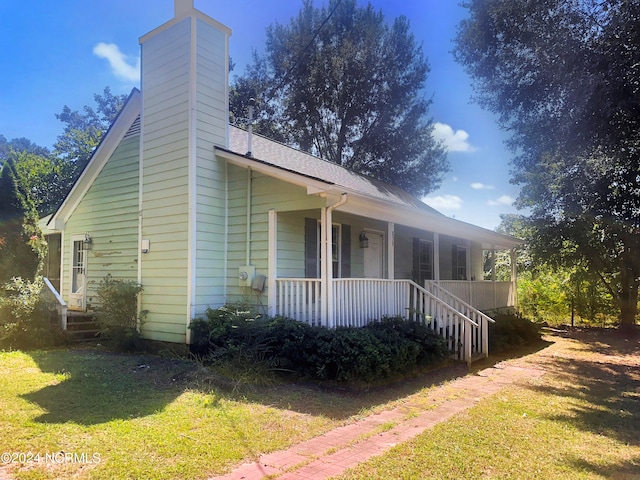 view of front of house with a front yard and a porch