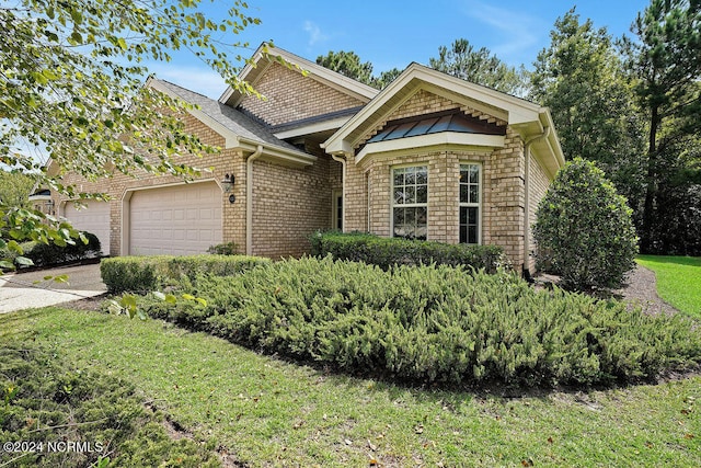 view of front of property featuring a front yard and a garage