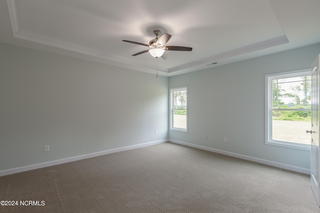 unfurnished room featuring crown molding, a tray ceiling, light carpet, and ceiling fan