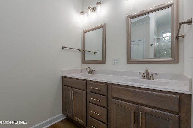 bathroom with vanity, a shower with shower door, ornamental molding, and hardwood / wood-style flooring