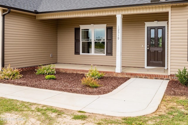 view of exterior entry featuring covered porch