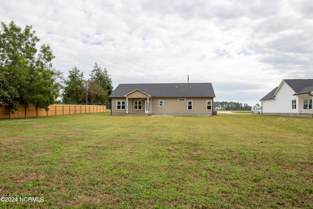 rear view of house featuring a yard