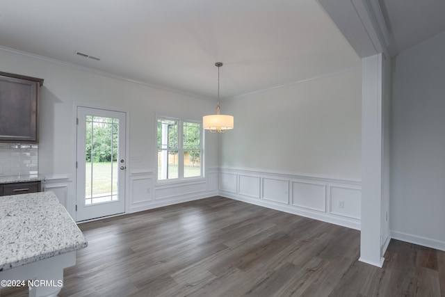 unfurnished dining area featuring ornamental molding and dark wood-type flooring