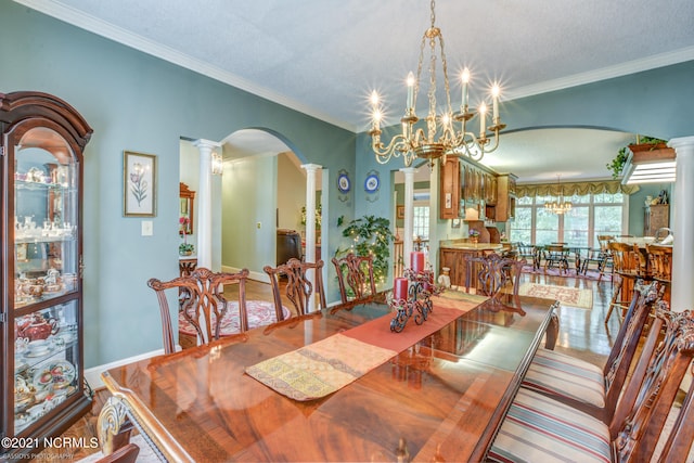 dining area with decorative columns, ornamental molding, and a notable chandelier