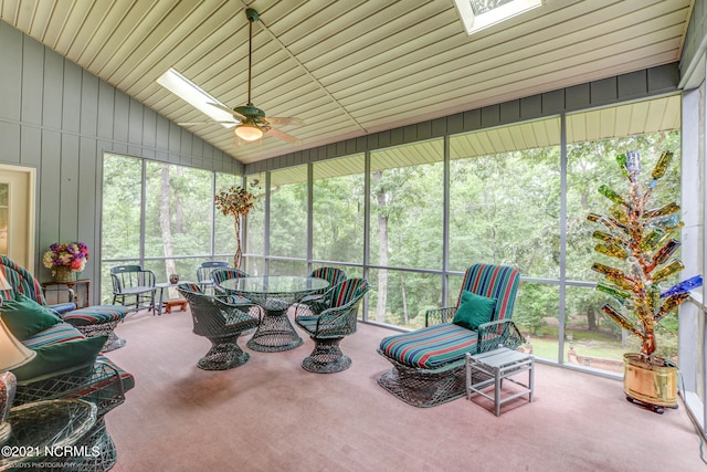 sunroom / solarium with ceiling fan and vaulted ceiling with skylight