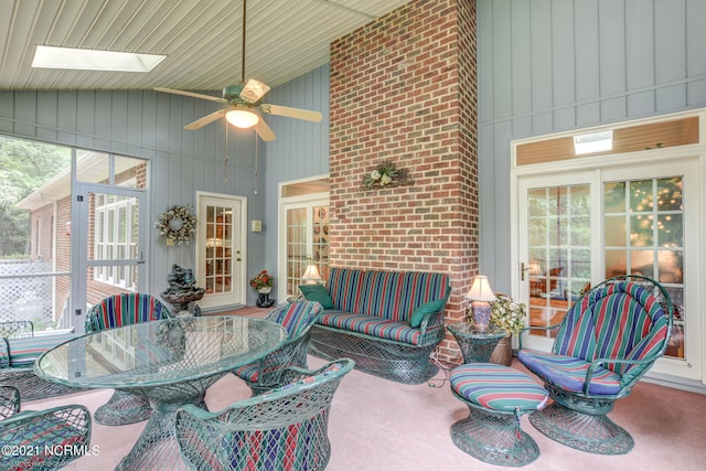 sunroom featuring ceiling fan and lofted ceiling with skylight