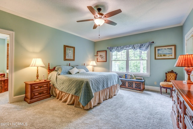 bedroom featuring light carpet, a textured ceiling, ceiling fan, and crown molding