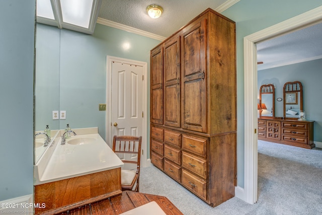 bathroom with ornamental molding, a textured ceiling, and vanity