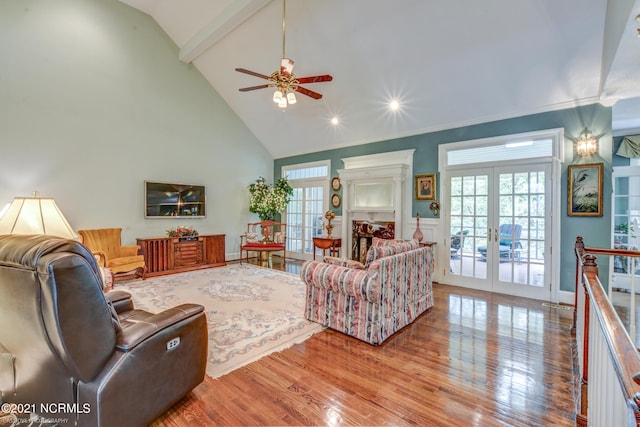 living room with ceiling fan, beamed ceiling, french doors, high vaulted ceiling, and light hardwood / wood-style floors