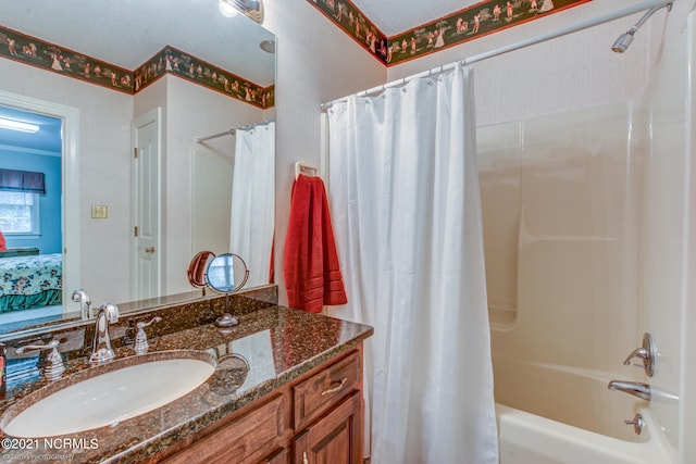 bathroom with shower / bath combination with curtain, a textured ceiling, and vanity