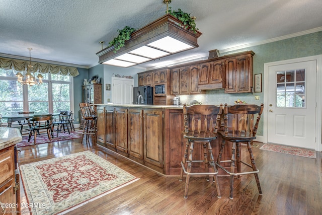 kitchen featuring a wealth of natural light, a chandelier, and hardwood / wood-style flooring