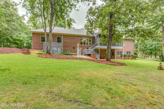 back of house with a yard and a sunroom