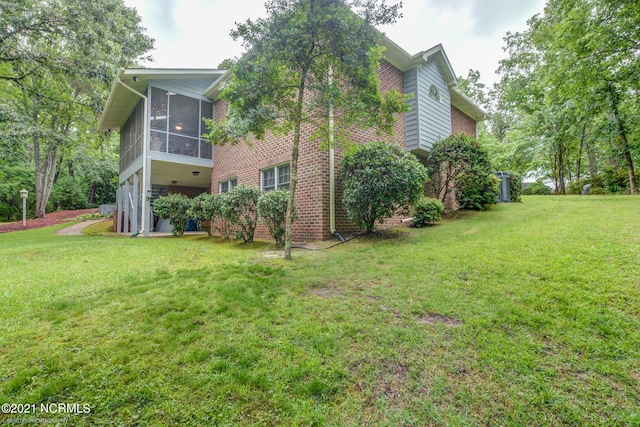 view of side of property with a lawn and a sunroom