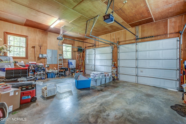 garage featuring a garage door opener and wooden walls