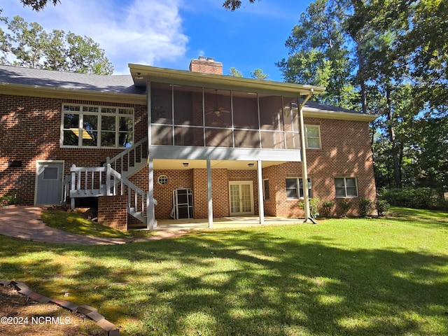 back of property featuring a sunroom, a lawn, and a patio