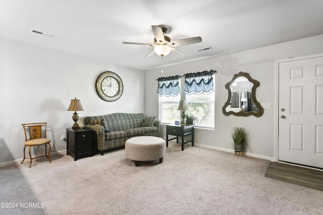 living area with carpet, ceiling fan, visible vents, and baseboards